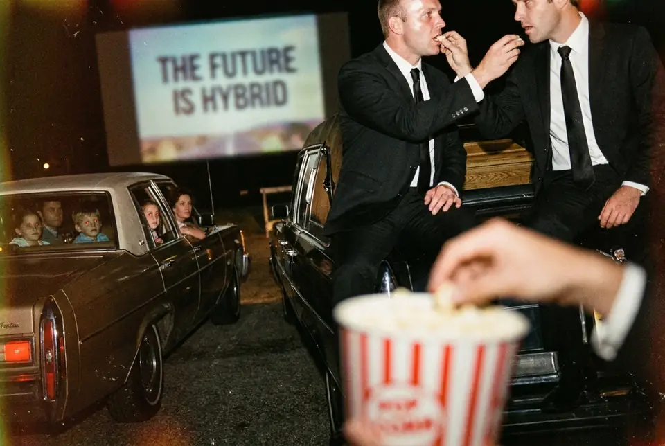 Campaign still: a drive-in cinema screen reads The Future Is Hybrid while two men in suits share popcorn