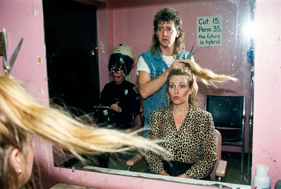 A hair salon price list reads Cut 15, Perm 35, the future is hybrid, while a police officer waits under a dryer