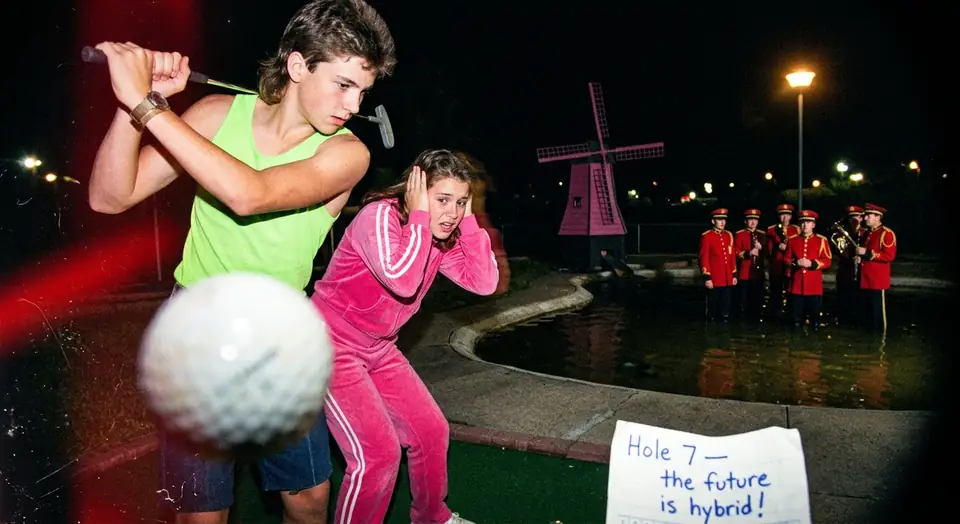 A golf ball flies at the camera on a mini golf course, a marching band plays by the windmill and a sign reads Hole 7, the future is hybrid